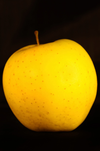 Yellow apple on black background