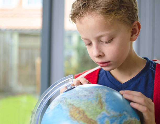 istock Boy studying map of the world 461916677