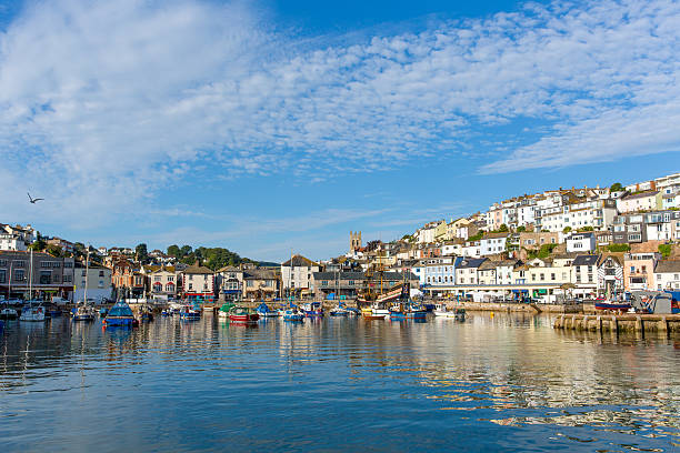 Brixham harbour Devon with boats moored on a calm still summer day with blue sky.  A traditional English coast scene.