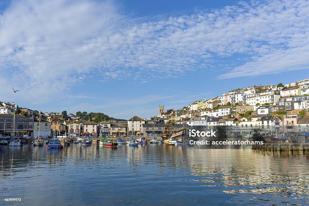 Brixham harbour Devon boats and blue sky Brixham harbour Devon with boats moored on a calm still summer day with blue sky.  A traditional English coast scene. Brixham Stock Photo