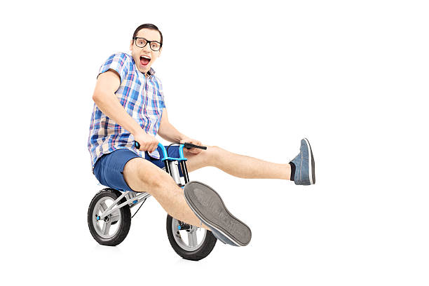 istock Funny young man riding a small bicycle 461925065