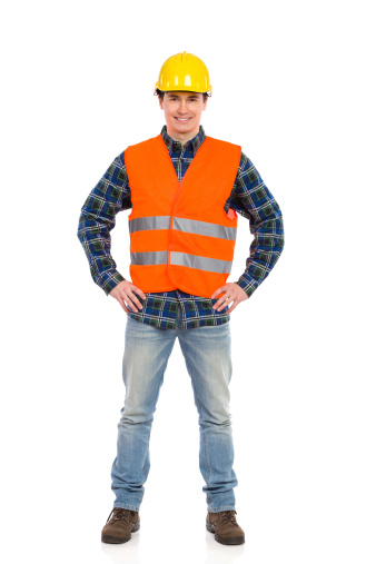 Smiling construction worker in yellow helmet and orange waistcoat.  Full length studio shot isolated on white.