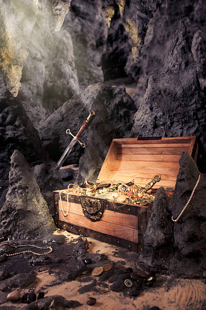istock open treasure chest with shinny gold in a cave 461931593
