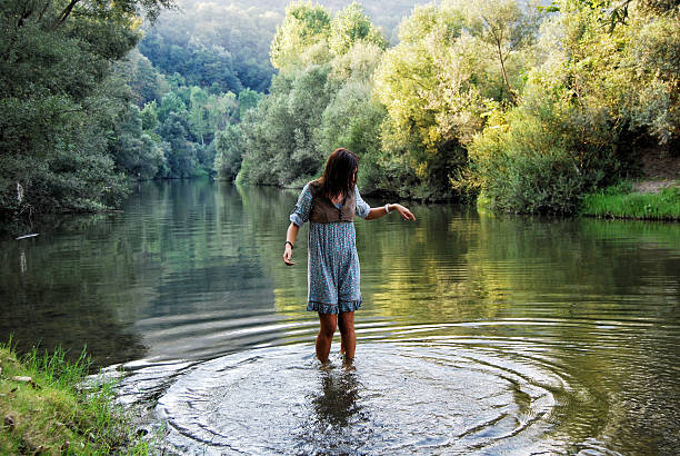 istock Young woman playing with water in lake 461932457