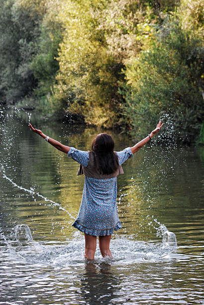 Young woman playing with water in lake