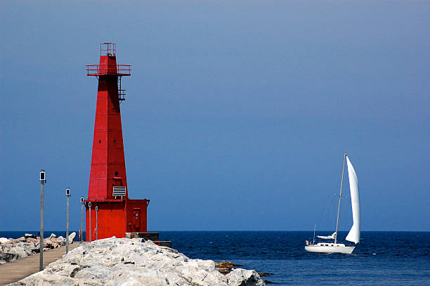 Lighthouse and sailboat, Muskegon, MI stock photo