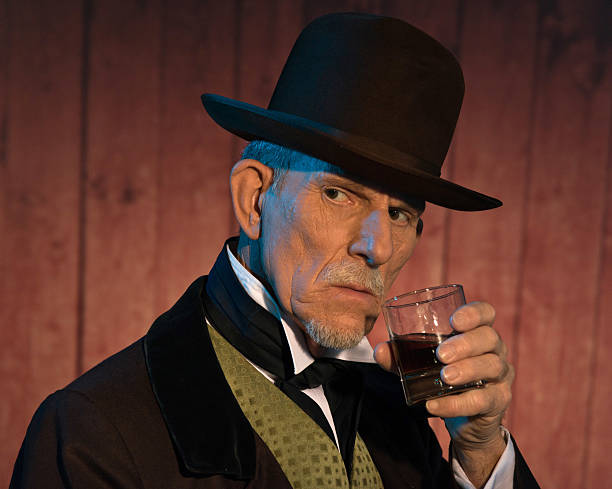 istock Senior alert western man wearing a brown hat drinking whiskey. 461943807