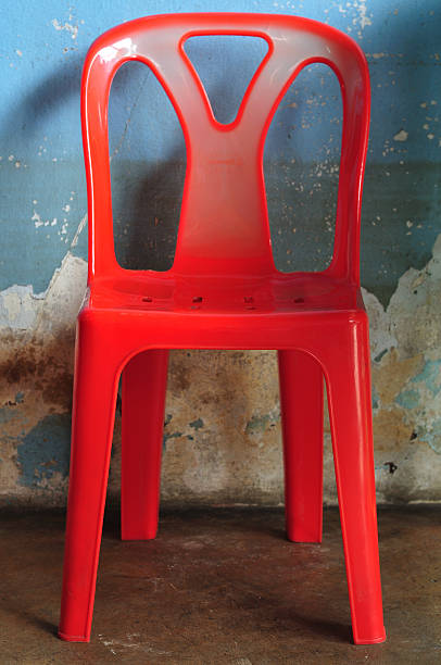 istock Old red plastic chair in front of blue wall. 461945011