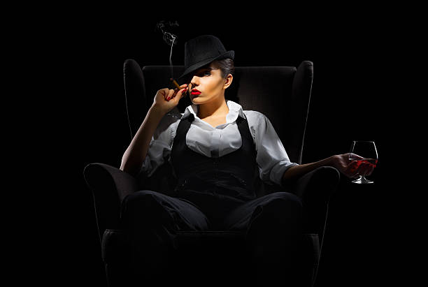 Mafiosi woman with cigar and brandy glass Mafiosi woman with cigar and brandy glass isolated smoking women luxury cigar stock pictures, royalty-free photos & images