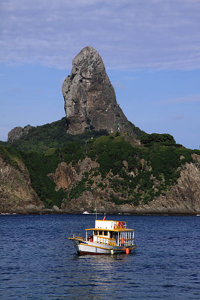 Morro do Pico rock and boat, Fernando de Noronha stock photo