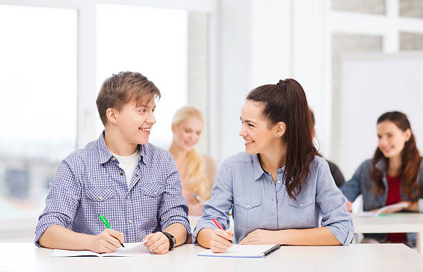 duas adolescentes com notebooks na escola - learning male studying smiling imagens e fotografias de stock