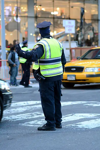 Photo of Patrolman guiding cars through traffic in the city