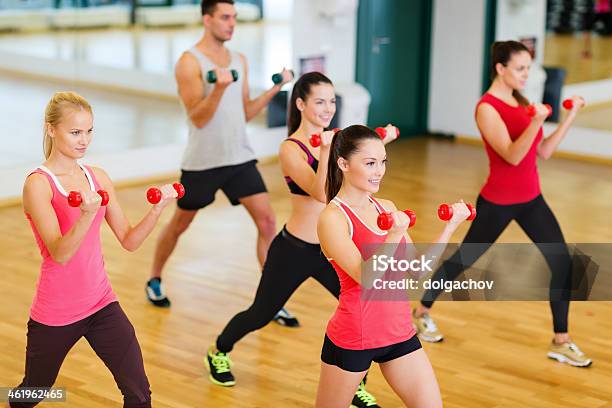 Group Of Smiling People Working Out With Dumbbells In Gym Stock Photo - Download Image Now