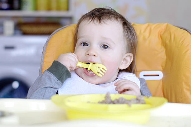 istock baby eating buckwheat groats 461964179