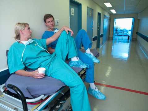 Group of people help female patient falling on the ground in hospital. Attractive African American women having an accident after doing physical therapy then rescued by doctor in corridor of clinic.