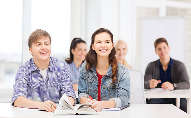 grupo de alunos, com notebooks e o livro na escola - learning male studying smiling imagens e fotografias de stock