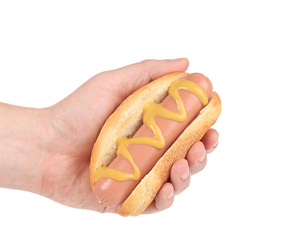Hotdog with mustard in hand.