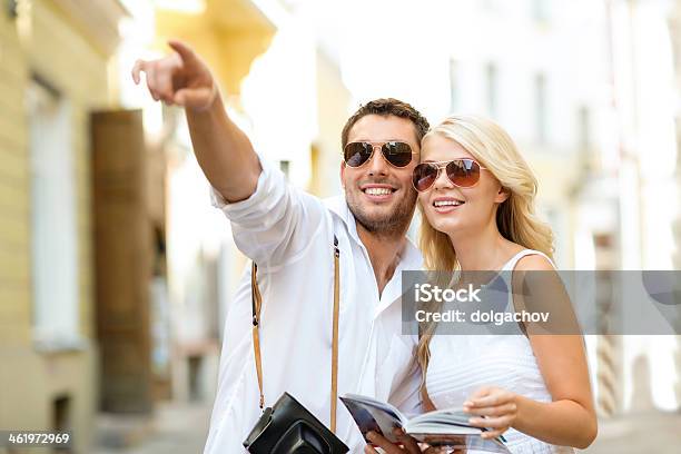 Couple With Camera And Travellers Guide In City Stock Photo - Download Image Now - Couple - Relationship, City, Guide - Occupation