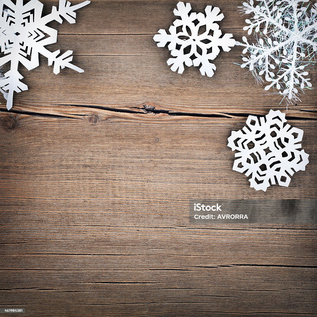 Paper cutout style snowflakes on a wooden background Christmas snowflakes on wooden background Backgrounds Stock Photo