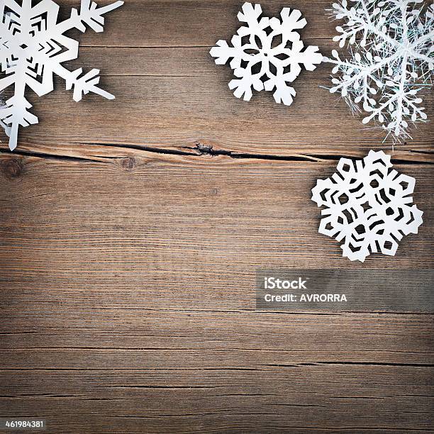 Paper Cutout Style Snowflakes On A Wooden Background Stock Photo - Download Image Now