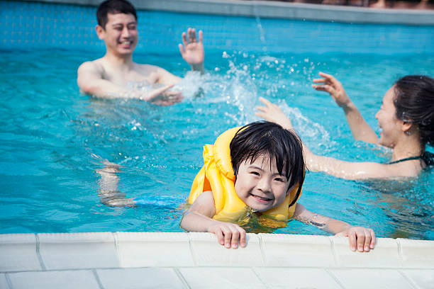 istock Smiling son in the water and holding onto pools edge 461988379