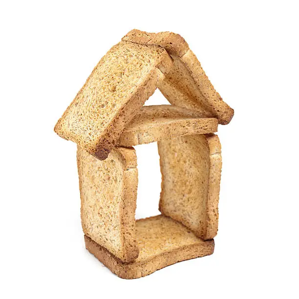 House shape made of slices of bread on a white background.