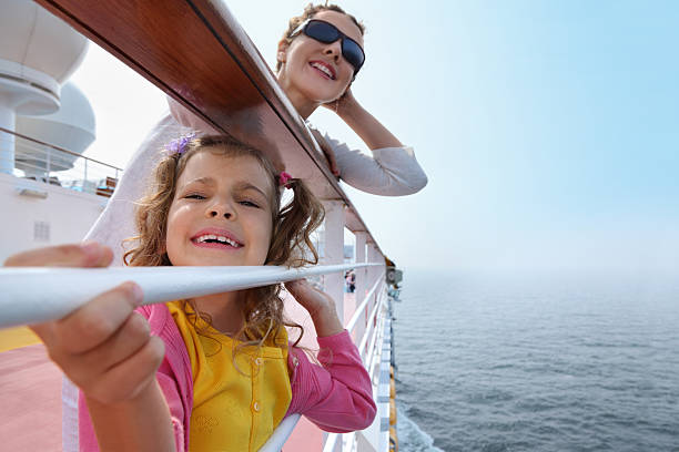 Mother and daughter traveling on cruise ship Smiling mother and daughter traveling on big cruise ship, other ship in sea cruise ship people stock pictures, royalty-free photos & images