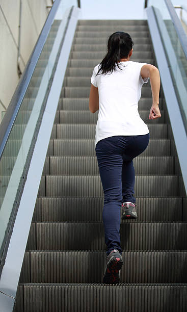 femme course sur l'escalator escaliers - railing beautiful human leg people photos et images de collection