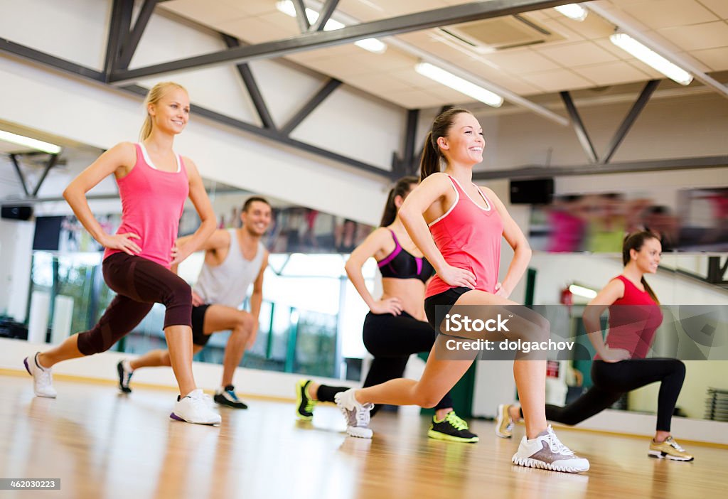 Sonriente mujer haciendo lunges en un gimnasio - Foto de stock de Aeróbic libre de derechos