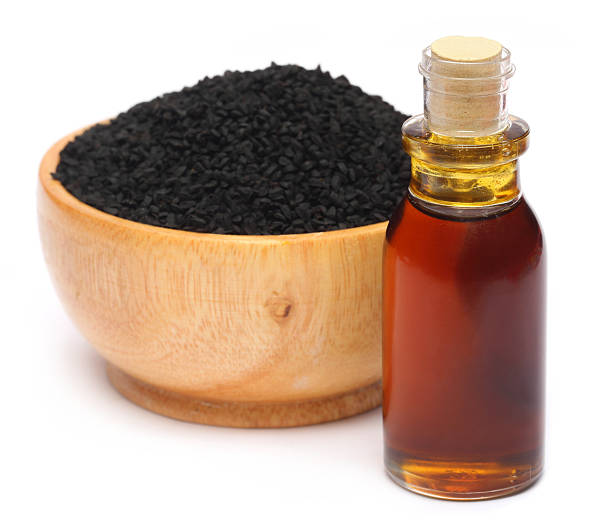 Nigella sativa or Black cumin with essential oil over white background