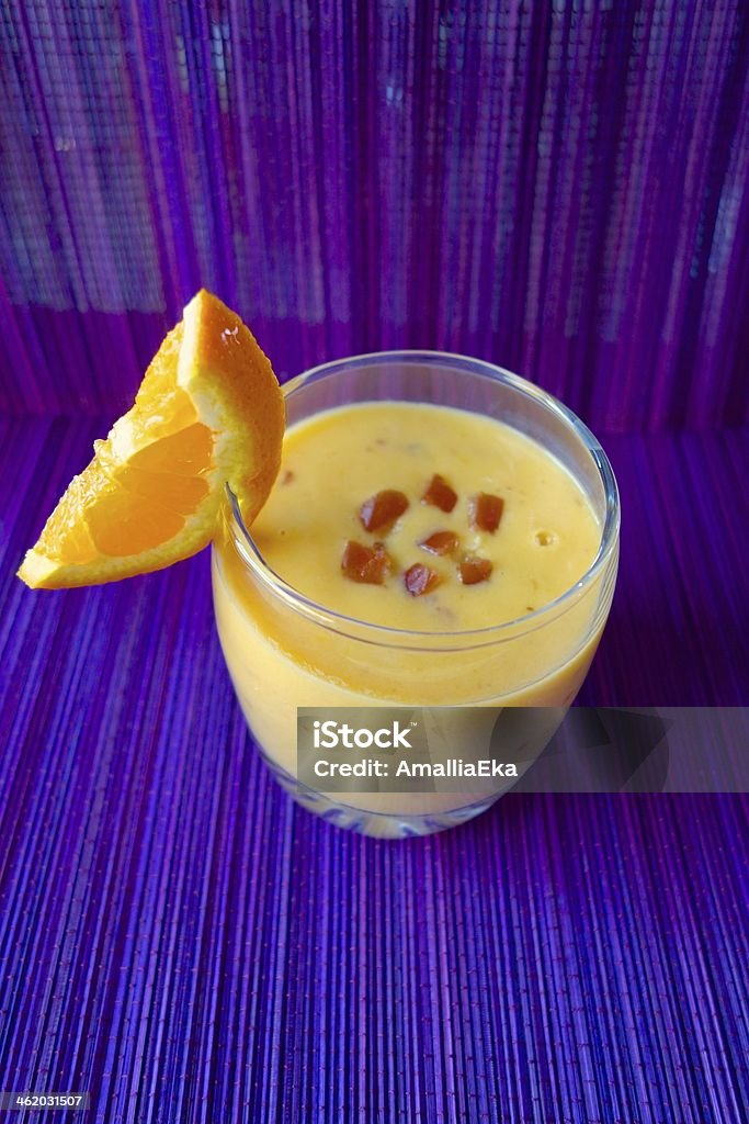 Mango date smoothie Mango orange date smoothie on purple background Colored Background Stock Photo