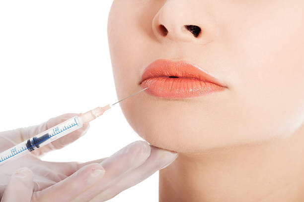 istock Young beautiful woman doing injection into mouth. 462036259