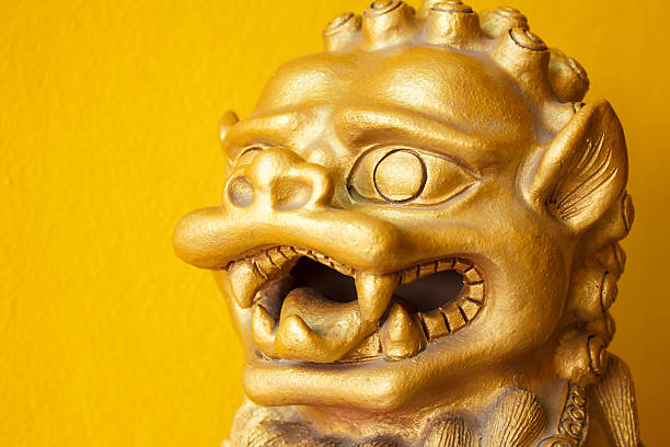 Chinese golden leo statue on yellow background Chinese golden head leo statue on  yellow background chinese temple dog stock pictures, royalty-free photos & images