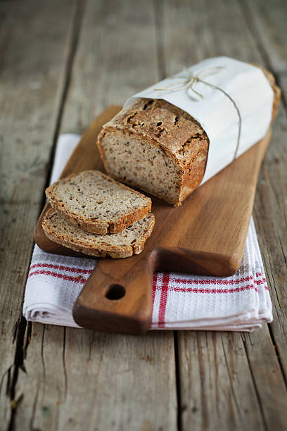 Loaf of oat bread on a wood cutting board stock photo