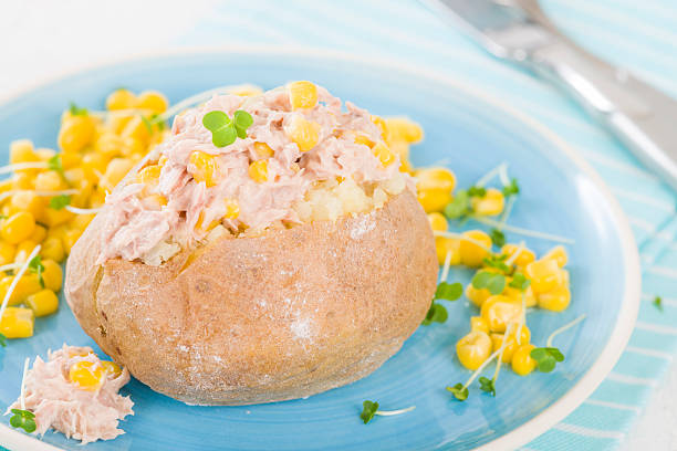Jacket Potato Jacket Potato - Baked potato topped with tuna and sweetcorn. tuna jacket potato stock pictures, royalty-free photos & images