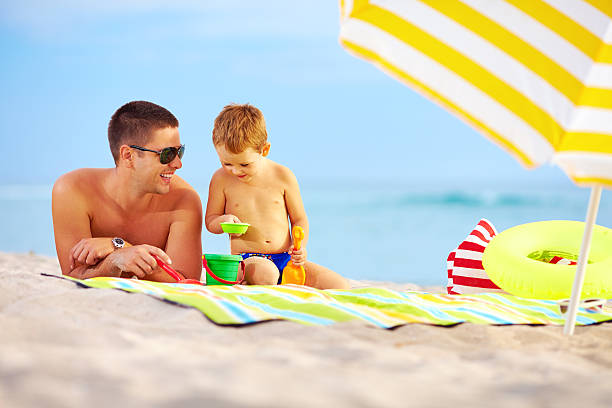 istock happy father and child playing in sand on the beach 462049771