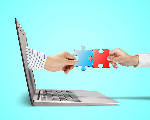 istock Hand holding puzzle coming out from screen connect with another 462050901