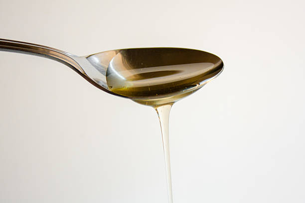 Agave nectar Agave nectar running off a metal spoon. pollination photos stock pictures, royalty-free photos & images