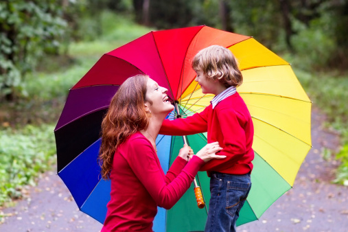Mother and son playing under a colorful umbrella