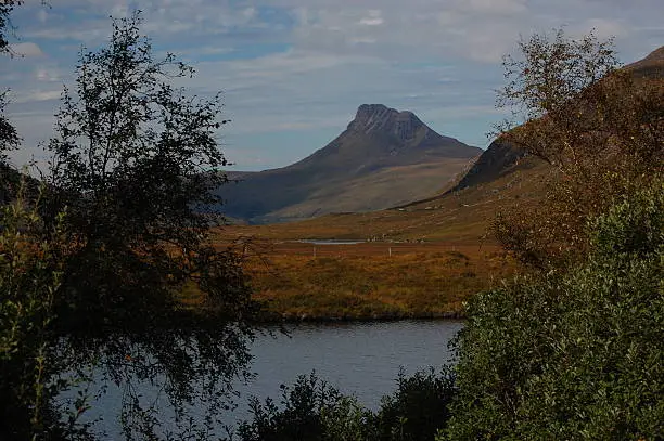 Stac Pollaidh framed by trees and lochan above Ullapool in western Scotland. On the road between Ullapool and Lochinver. Taken in September.