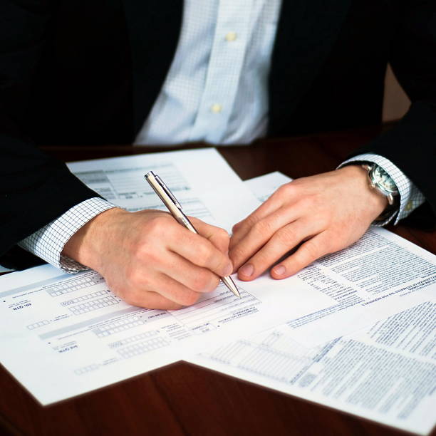 istock Business men filling out some documents on a desk. 462067877