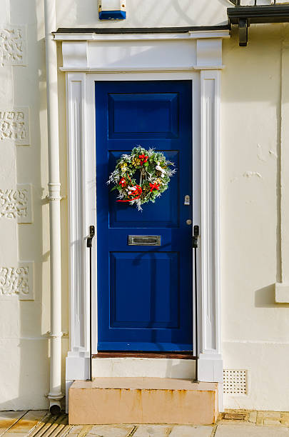 blue door avec couronne de noël - doorstep door knocker door england photos et images de collection