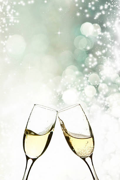 Glasses with champagne against holiday lights stock photo