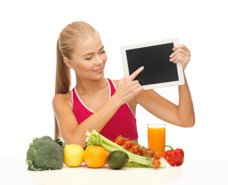 people, healthy eating and diet concept - sporty woman with fruits and vegetables pointing at tablet pc