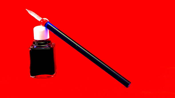 istock pen glass over inkpot with red background 462095507