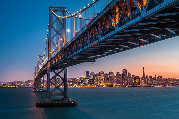 Framing San Francisco San Francisco skyline framed by the Bay Bridge at sunset bay bridge stock pictures, royalty-free photos & images