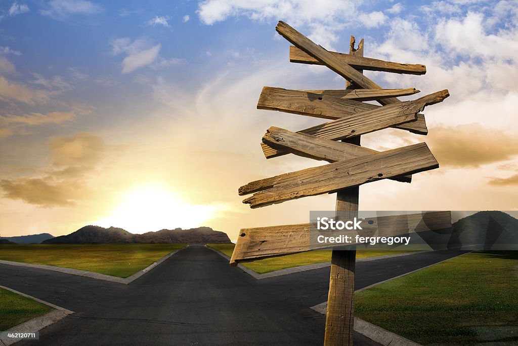 crossroads with confusing directional arrow sign Concept of being lost with a roadsign Forked Road Stock Photo