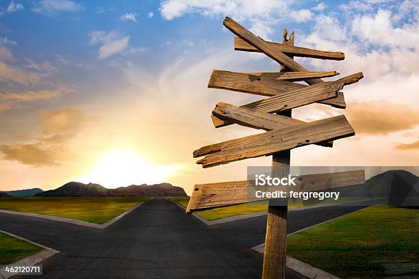 Crossroads With Confusing Directional Arrow Sign Stock Photo - Download Image Now - Forked Road, Crossroad, Crossroads Sign