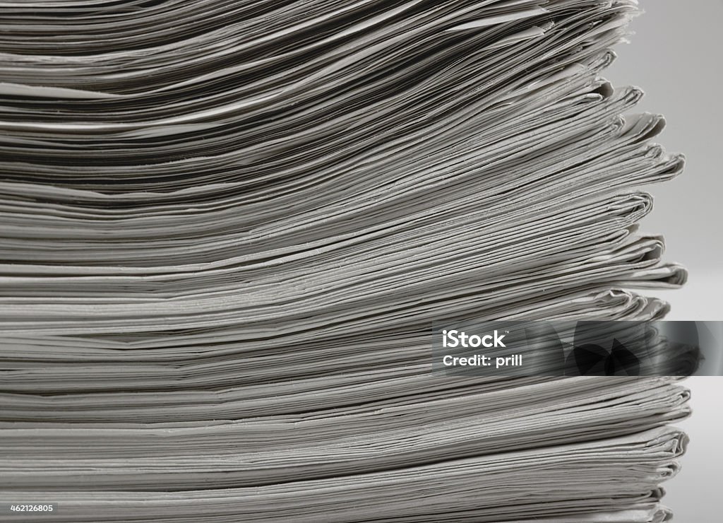 lots of newspapers lots of stacked newspapers in light back Abundance Stock Photo