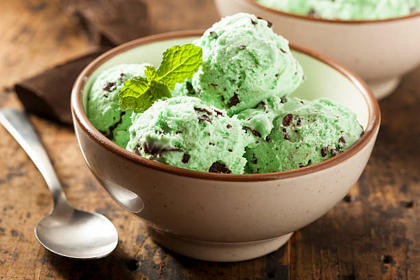 Organic Green Mint Chocolate Chip Ice Cream Organic Green Mint Chocolate Chip Ice Cream with a Spoon scoop shape photos stock pictures, royalty-free photos & images